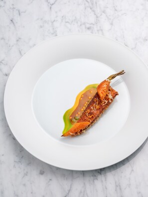 A white plate with a piece of food on a marble surface.