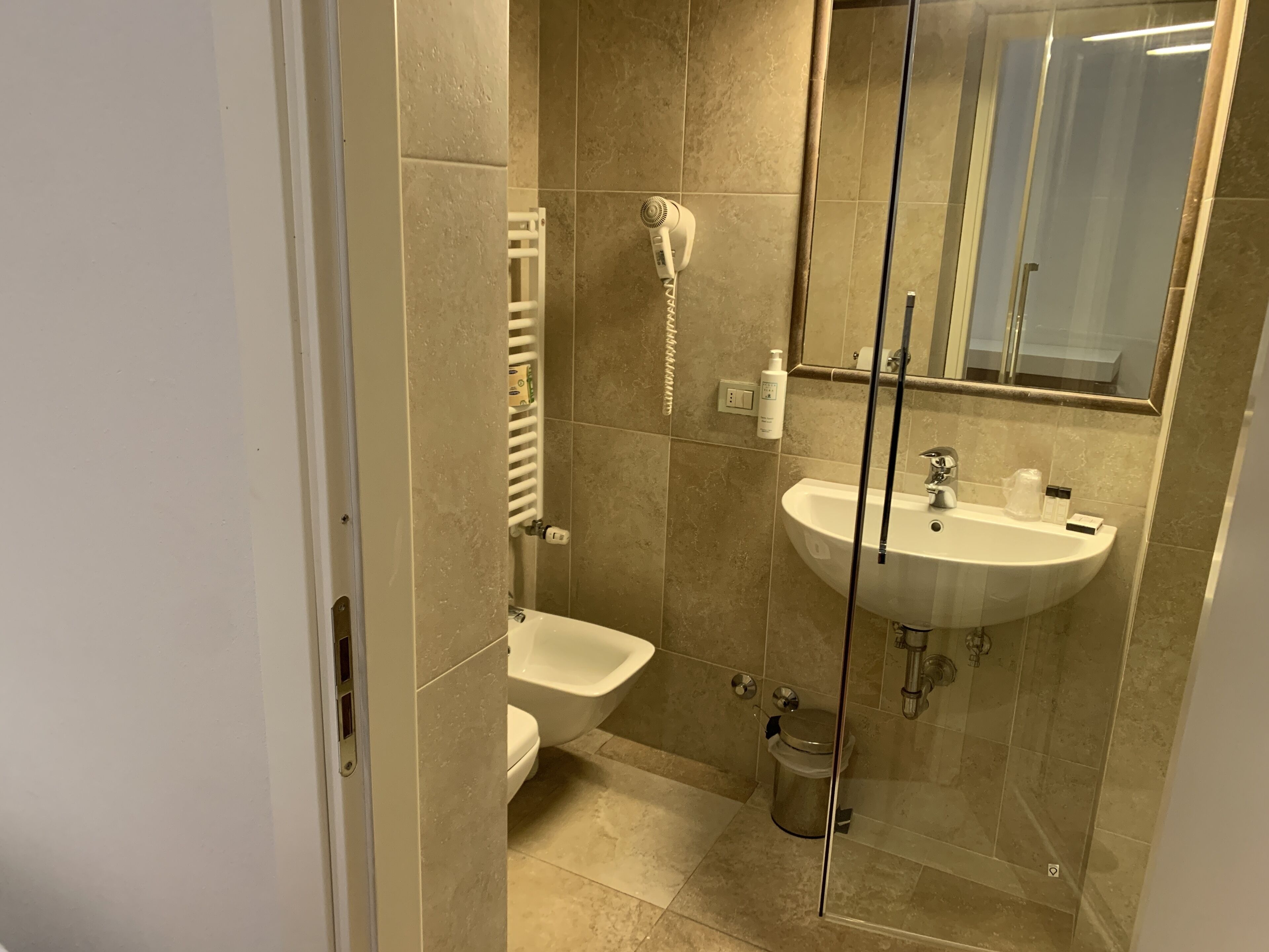 Ein modernes Badezimmer mit Duschkabine aus Glas, einem weißen Waschbecken und einem Bidet.