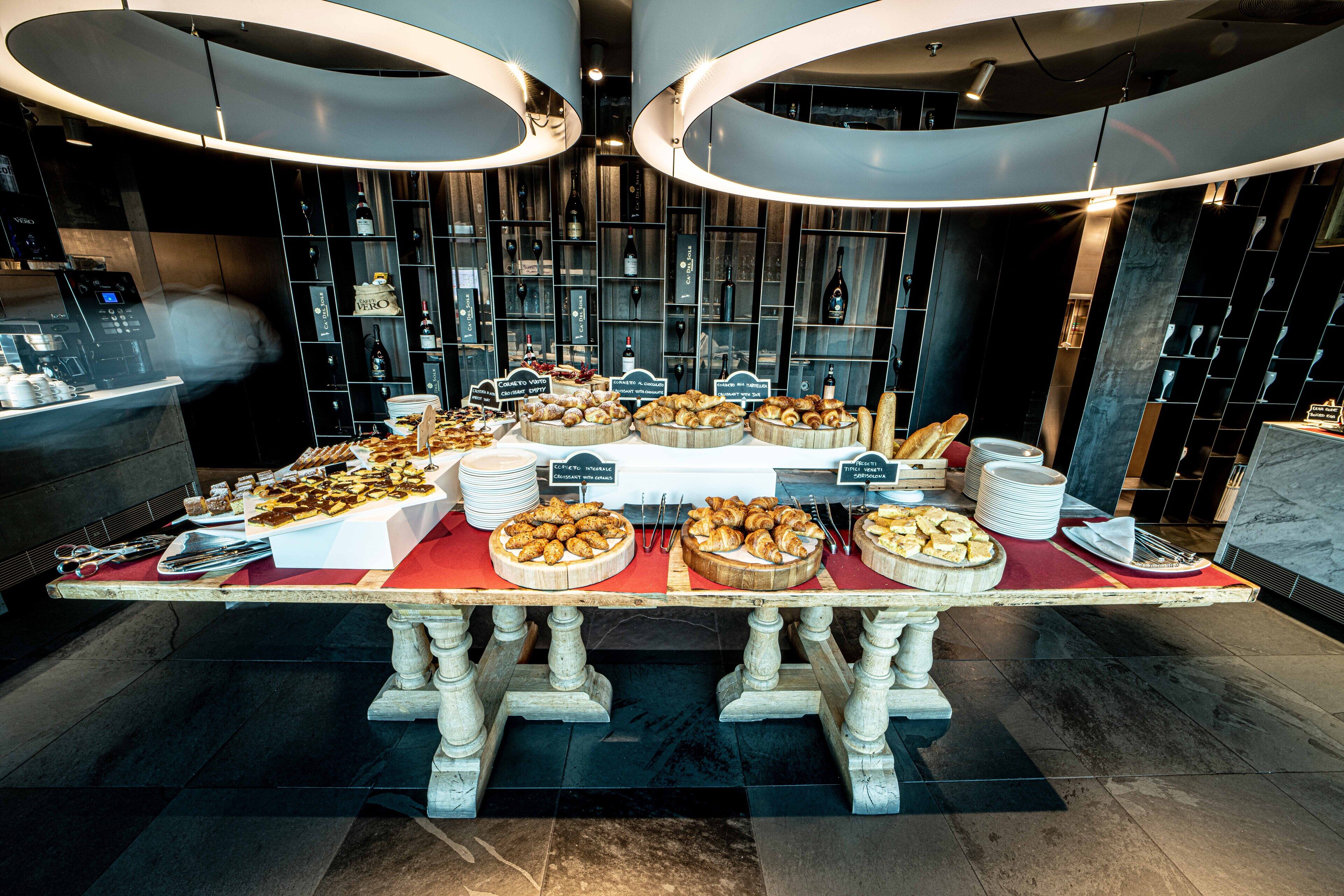 A buffet table with various food items and a wine display in the background.