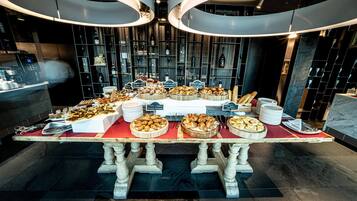 A buffet table with various food items and a wine display in the background.