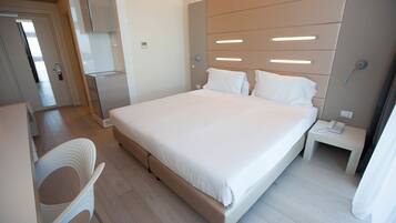 A modern hotel room with a large bed, a desk, and a chair.
