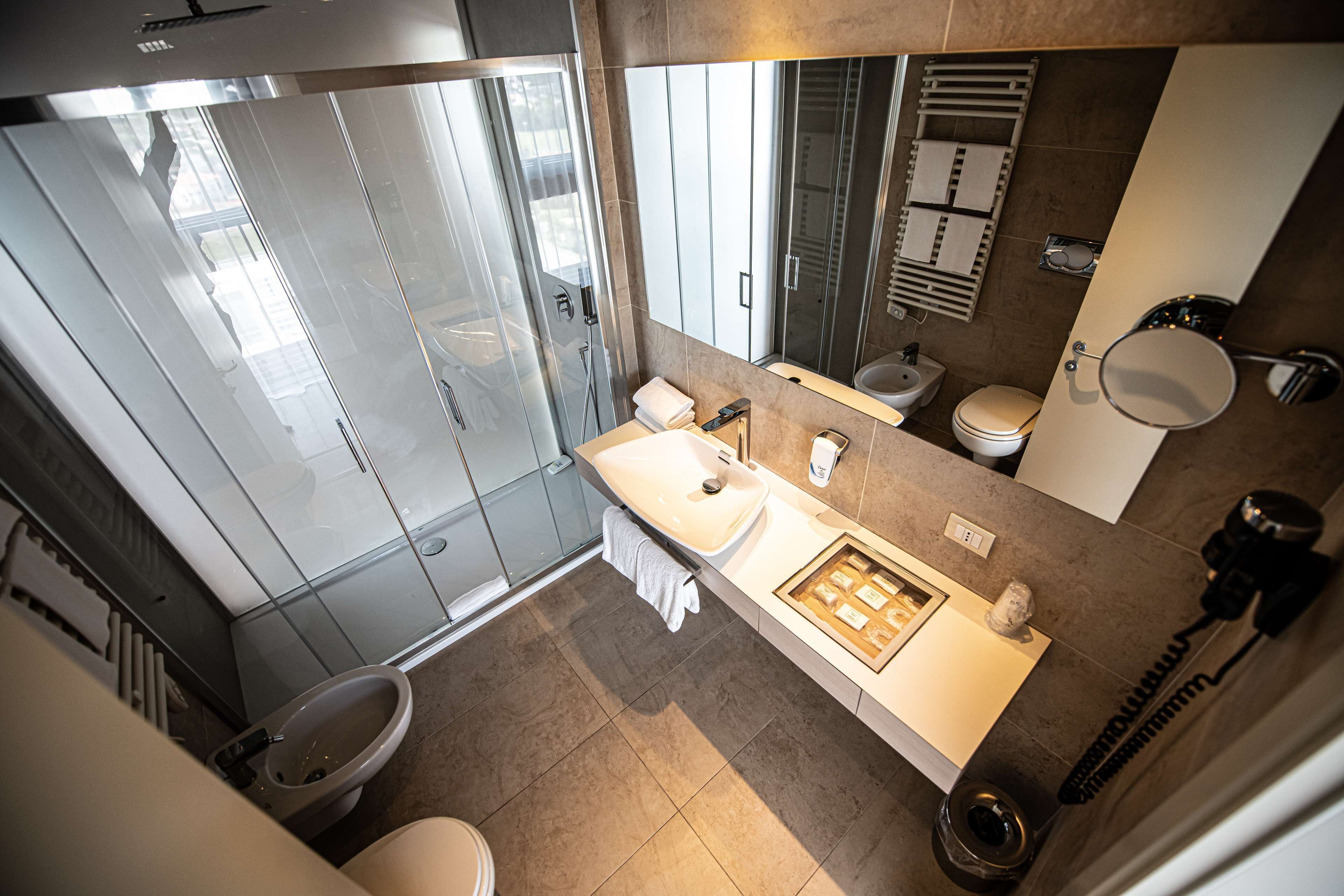A modern bathroom with a glass shower enclosure, a vanity with a sink, and a toilet.
