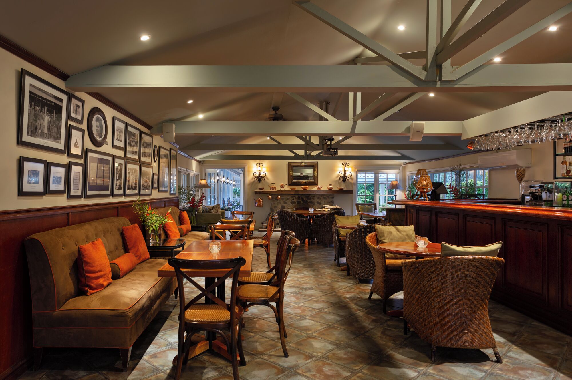 A spacious dining area with a high ceiling and exposed beams, featuring a bar with a counter and bar stools.