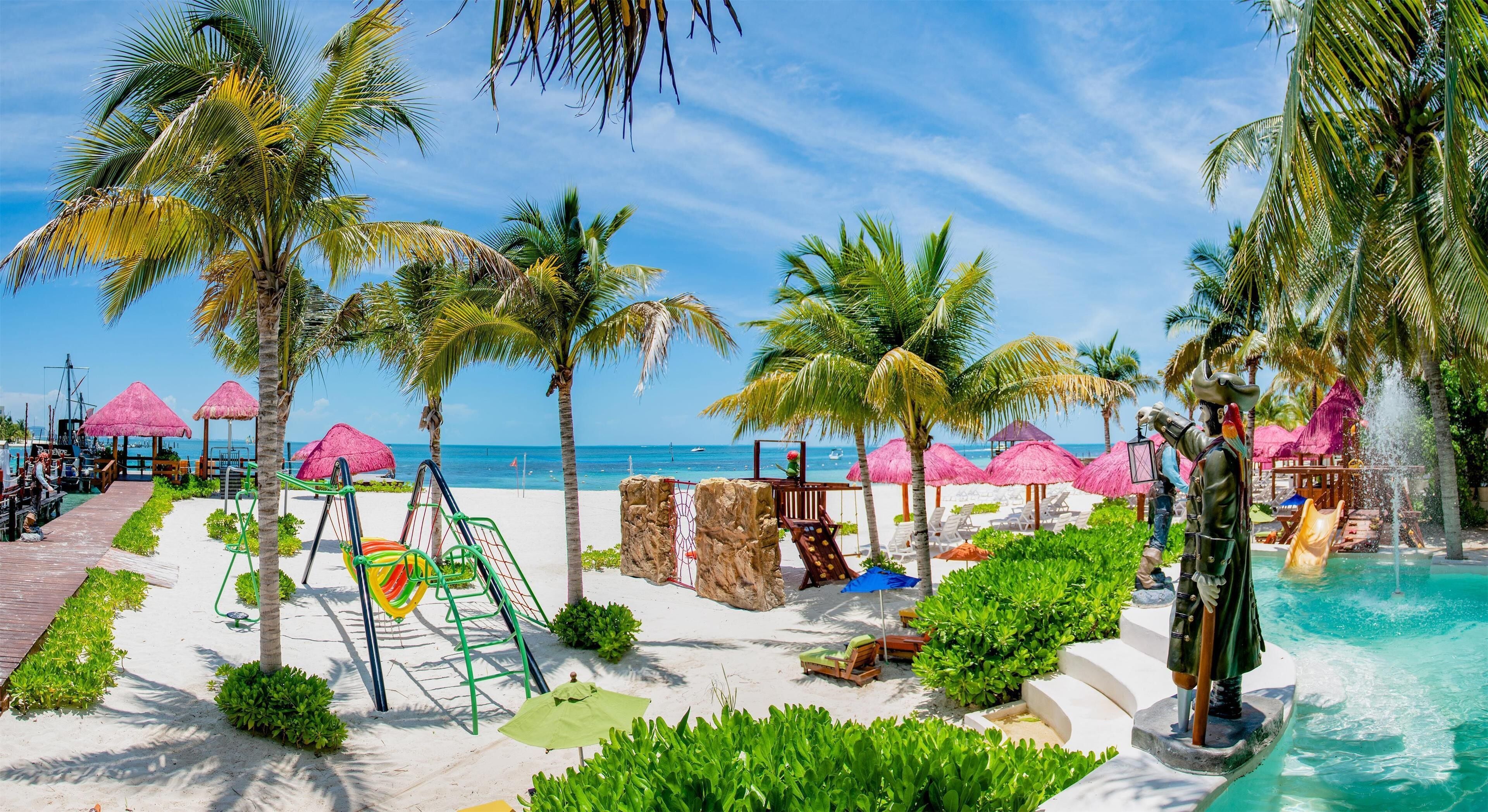 A beach resort with a pool, palm trees, and beach chairs.
