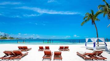 On the beach, white sand, sun loungers, beach towels