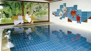 An indoor swimming pool with tiled walls and a wooden ceiling. - Hotel Ochsenwirtshof (Bad Rippoldsau-Schapbach)