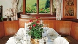 A dining table set for four with a view of a green landscape through a window. - Hotel Ochsenwirtshof (Bad Rippoldsau-Schapbach)