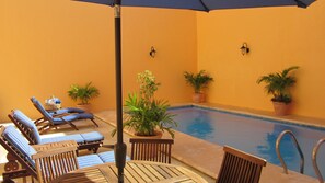 Una piscina al aire libre, sillones reclinables de piscina