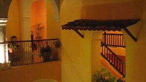 A multi-level interior with a staircase, balconies, and potted plants. - Hotel Castelmar (Campeche)