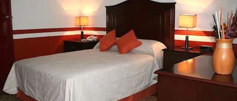 A hotel room with a large bed, two bedside tables, and a nightstand.