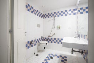 Un baño con inodoro, lavamanos y ducha.