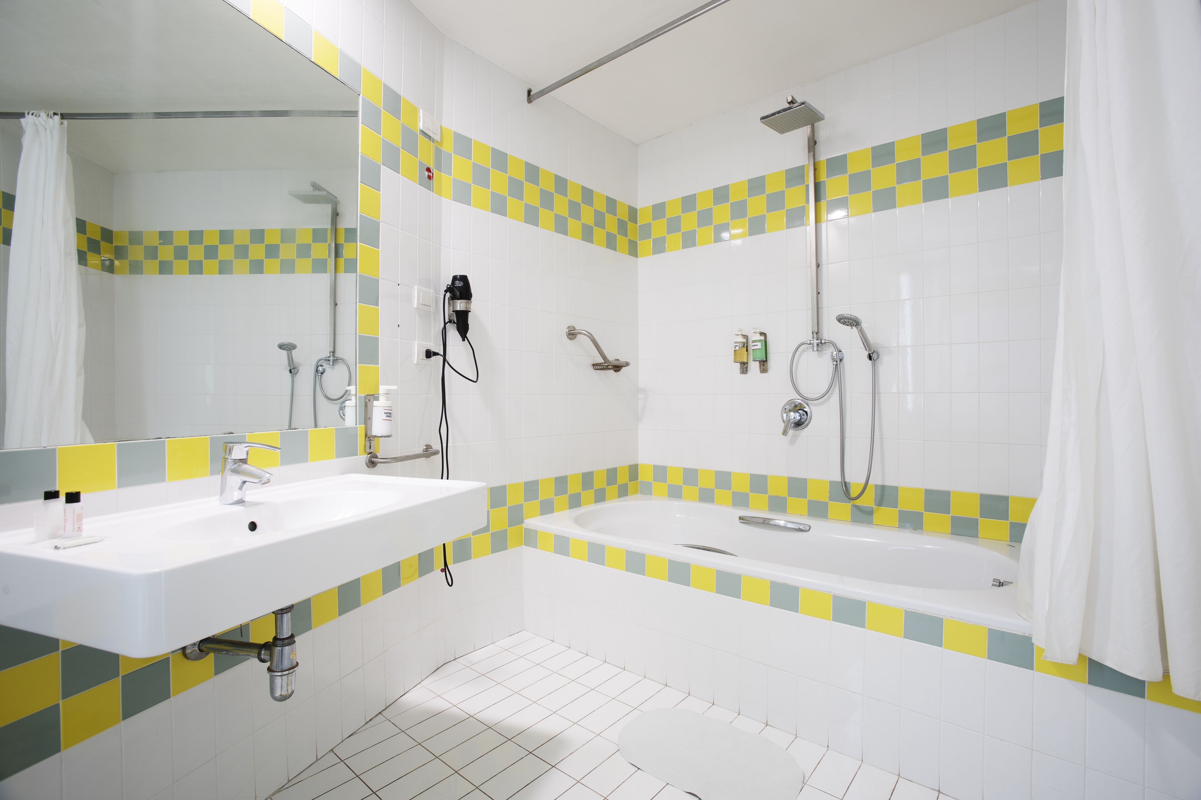 A bathroom with two sinks, a bathtub, and a shower.