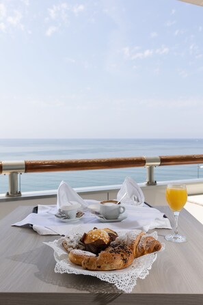 A table with pastries, a cup of coffee, and a glass of orange juice, overlooking the sea. - Grand Hotel Salerno (Salerno)