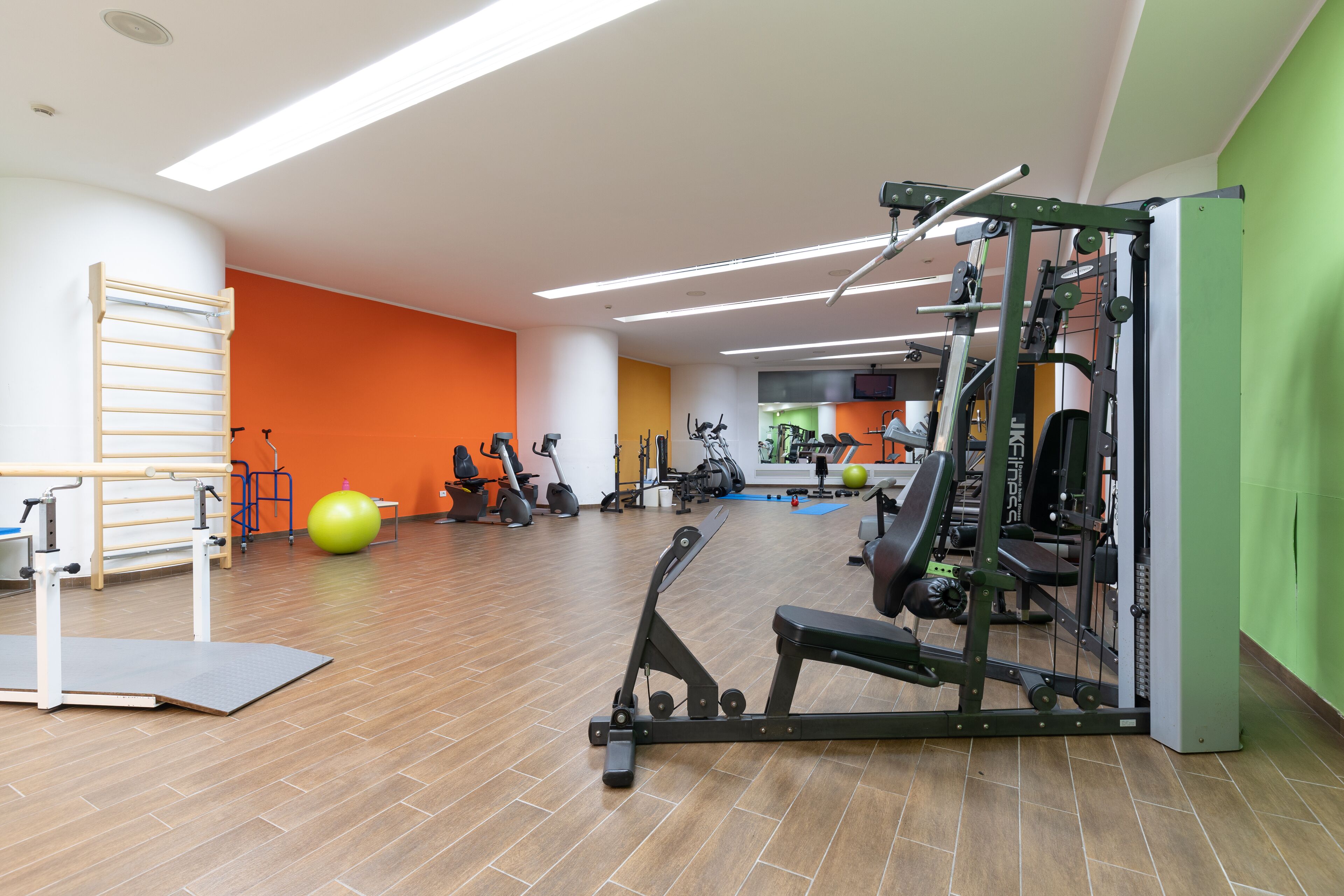 Un gimnasio con equipo de ejercicio, una barra de dominadas y una pelota de yoga.