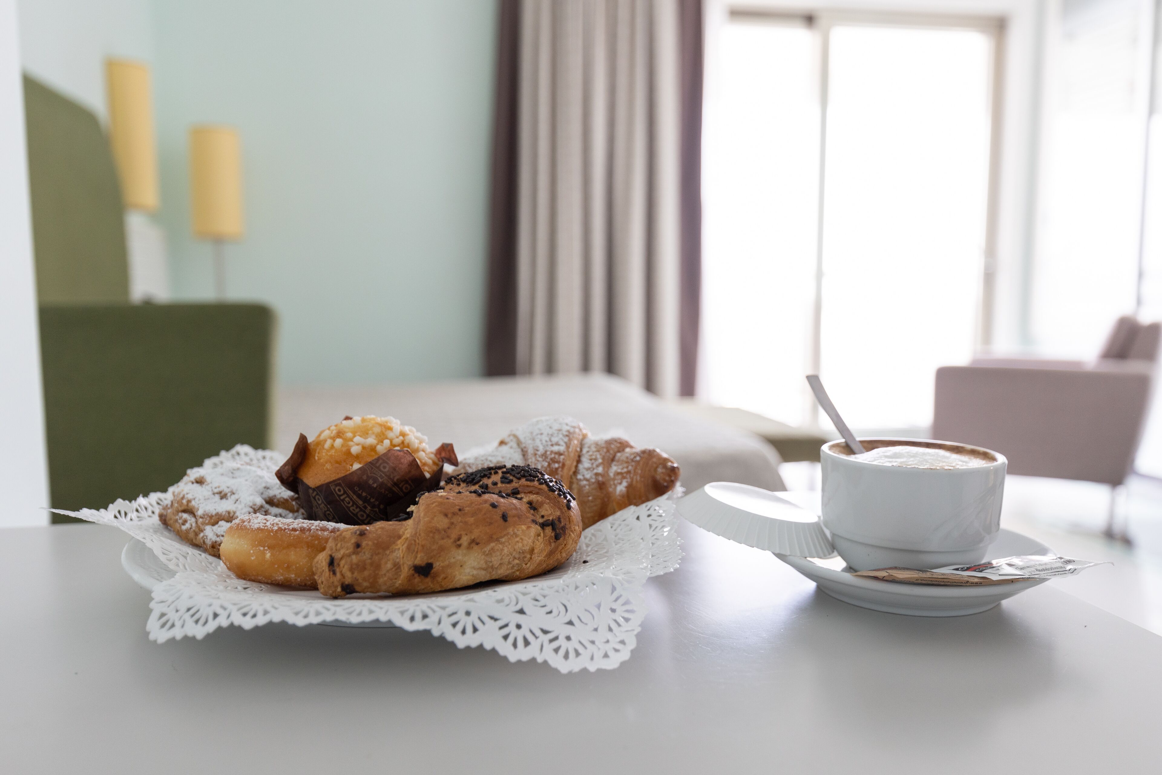 Een ontbijttafel met gebak en een kop koffie.