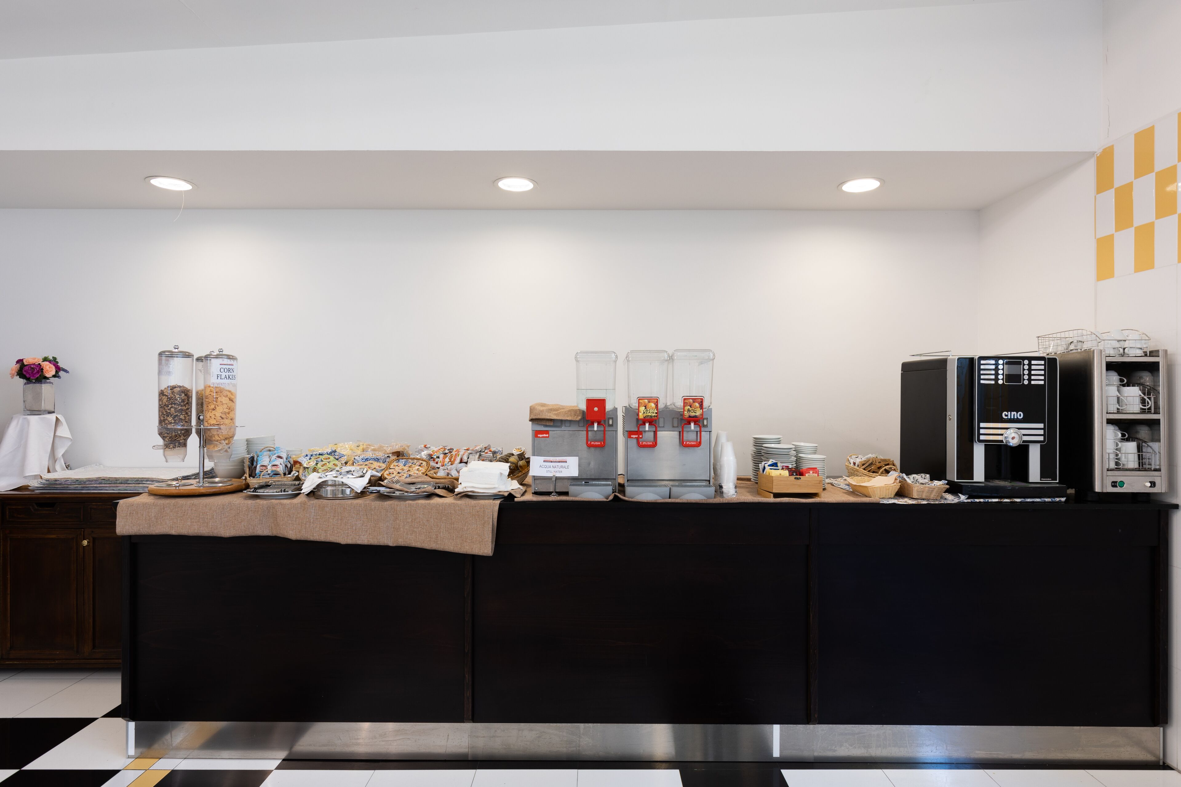 A modern kitchen area with a coffee station, a refrigerator, and a microwave.