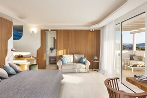Une chambre d’hôtel moderne équipée d’un lit, d’un canapé, d’une table à manger et d’un balcon avec vue.
