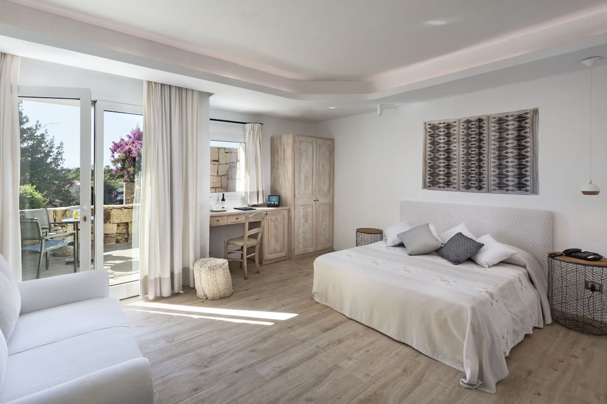Een slaapkamer met een bed, een bureau en een stoel.