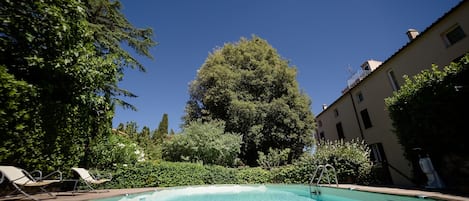 Una piscina al aire libre, tumbonas