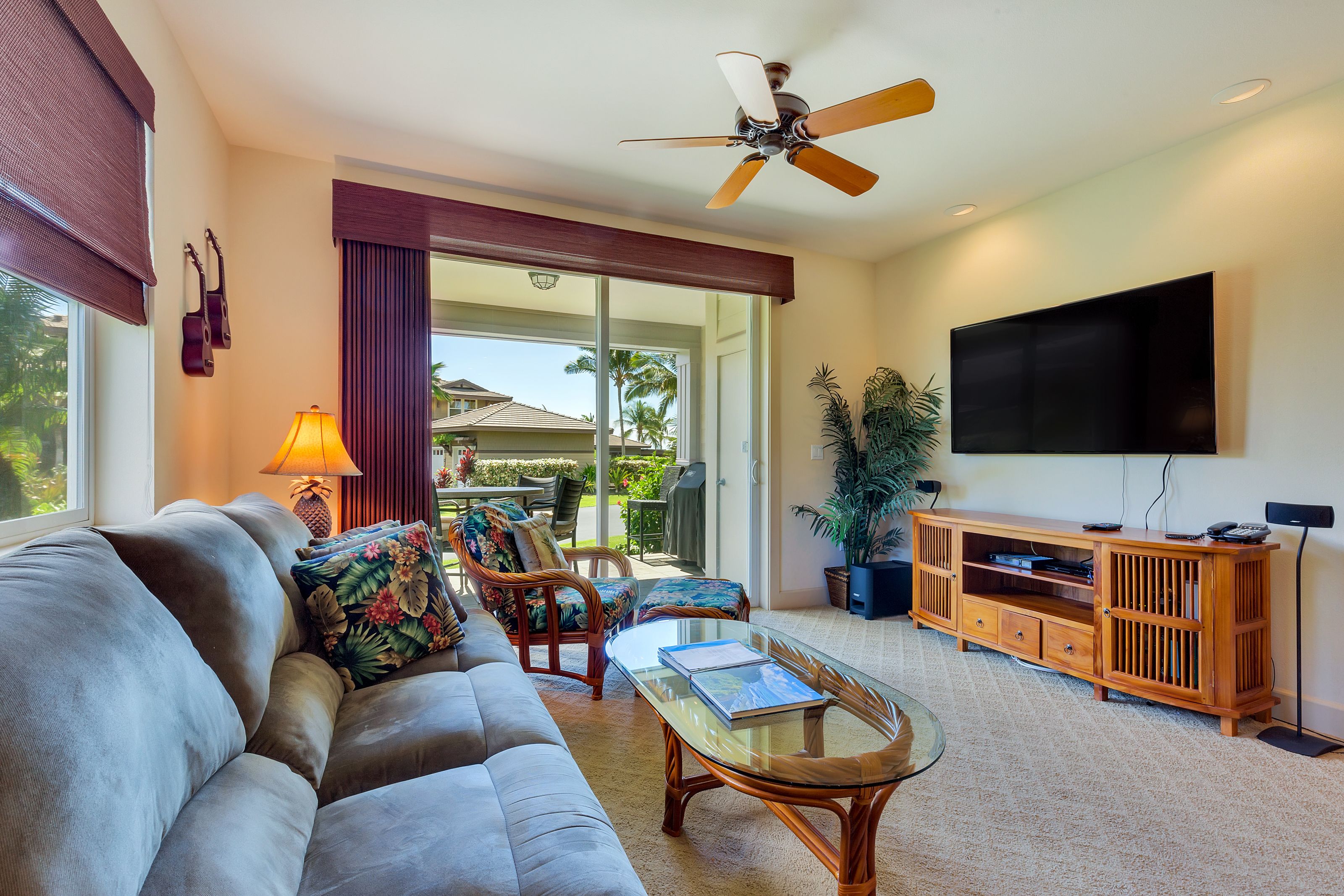 A spacious living room with a sofa, coffee table, and a TV on a wooden stand.
