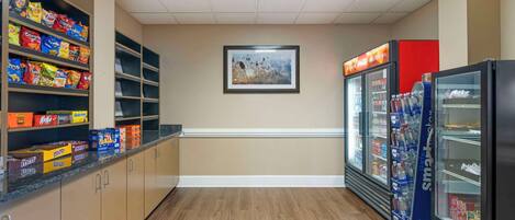 A snack bar with shelves stocked with various snacks and a refrigerated display case.