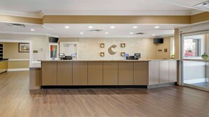A reception area with a counter, a television, and a wall-mounted clock.
