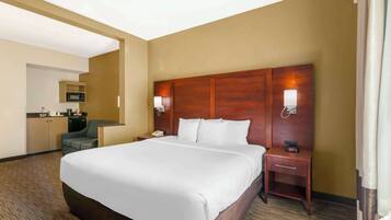 A hotel room with a large bed, a desk with a telephone, a microwave, and a chair.