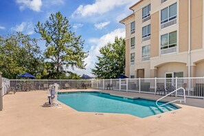 A pool area with a white fence, lounge chairs, and umbrellas. - Comfort Suites Valdosta Mall Area (Valdosta)