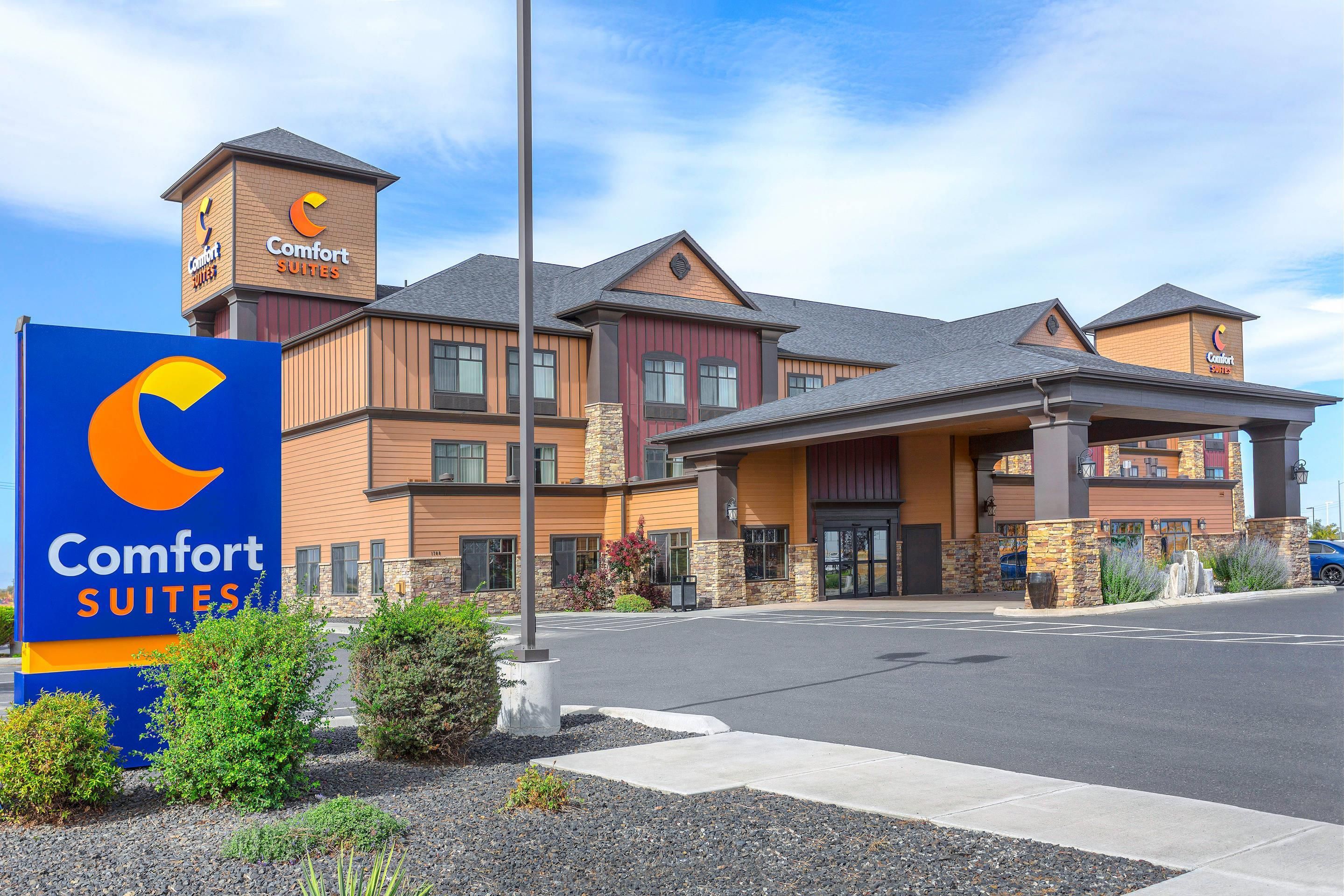 A Comfort Suites hotel with a prominent sign, a covered entrance, and a brick facade.