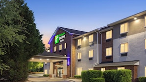Een Holiday Inn Express gebouw met een bakstenen gevel, meerdere ramen en een goed verlichte ingang.