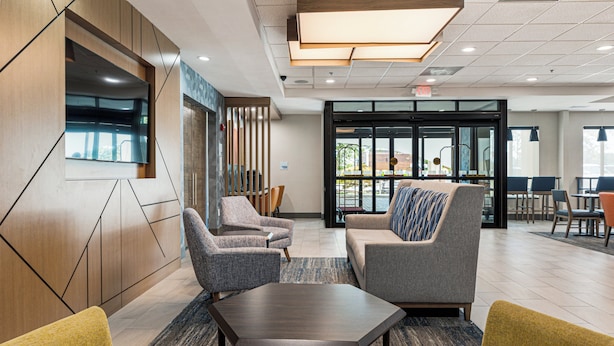 Een moderne lobby met zithoeken, een receptiebalie en grote ramen.