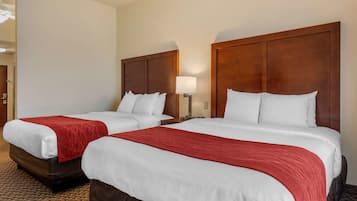 Two double beds with wooden headboards, white bedding, and red throw blankets.