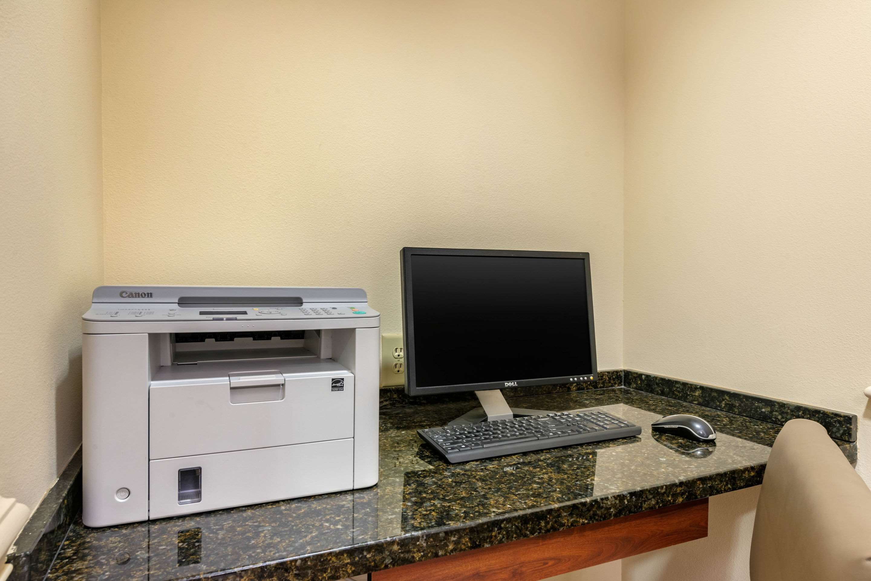 A desk with a Canon printer, a Dell monitor, a keyboard, and a mouse.