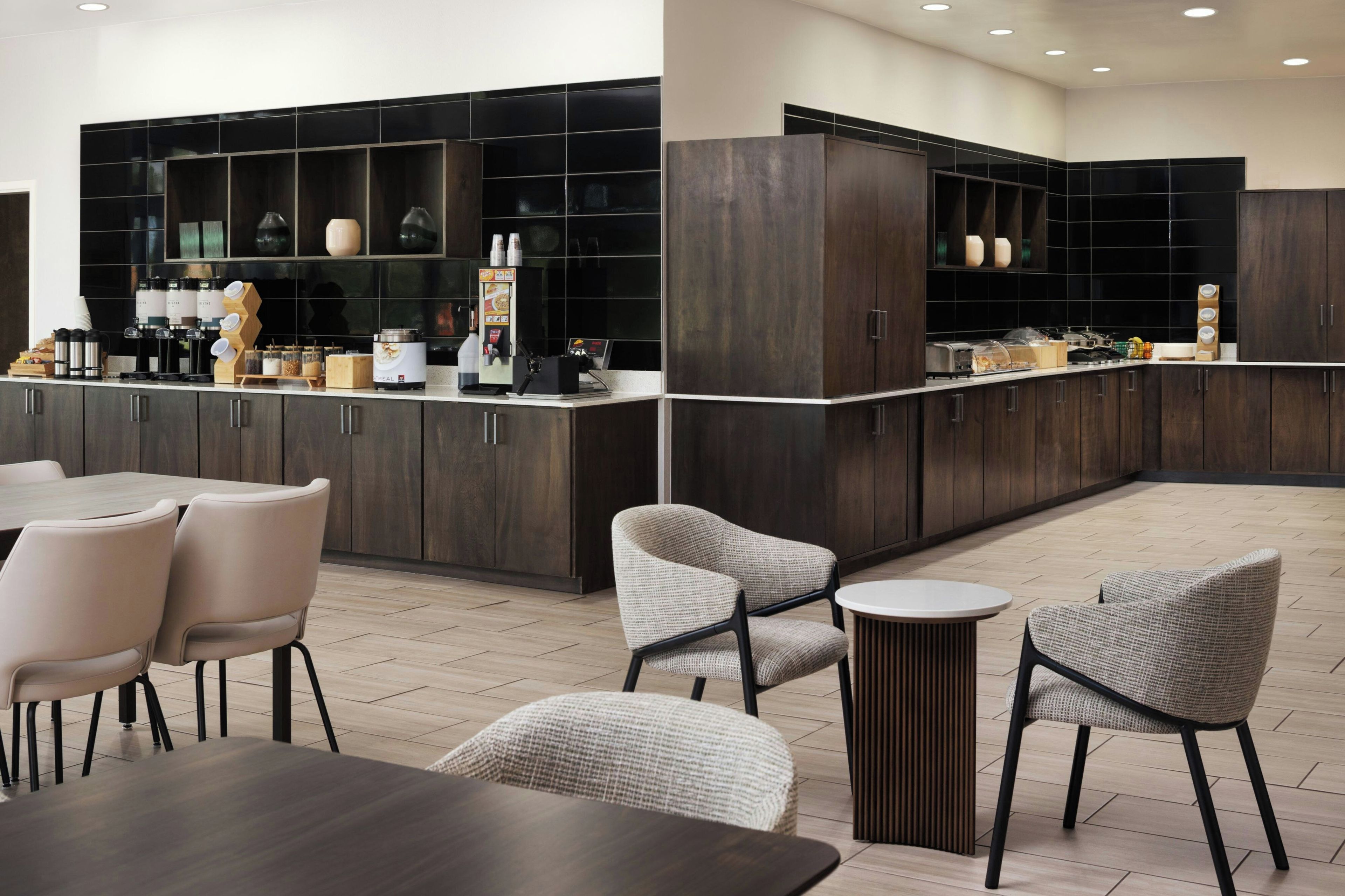 A modern hotel lobby with a bar area, seating arrangements, and a coffee station.