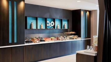 Une cuisine moderne dotée d’un îlot central, de meubles de cuisine en bois foncé et d’un pare-feu bleu.