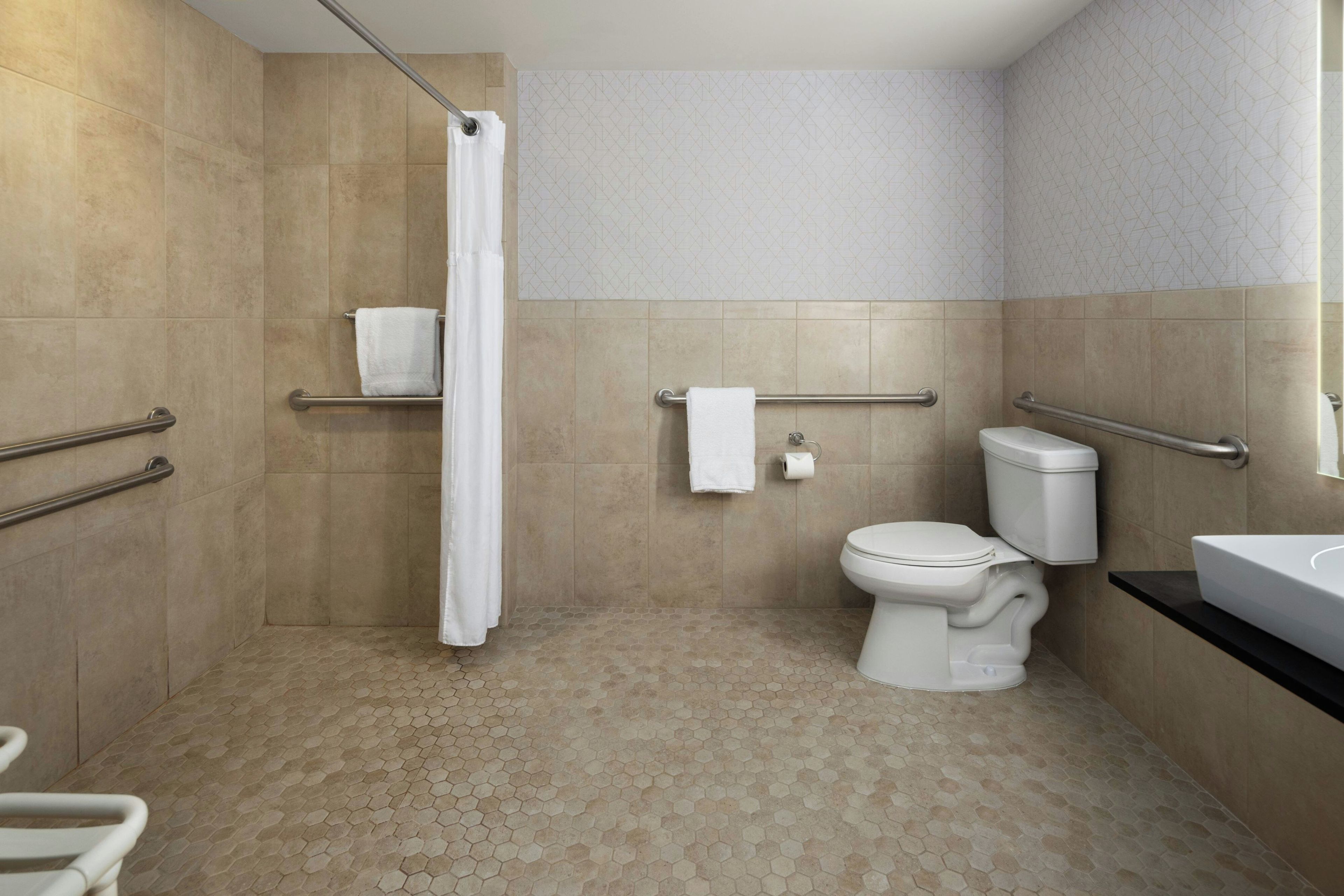 Un baño moderno con ducha, inodoro y lavamanos.