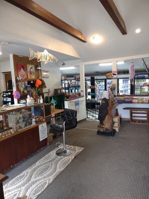 A spacious lobby with a reception desk, a seating area, and a display of various items.