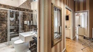 Un bagno moderno con doccia vetrata, lavandino bianco e WC.
