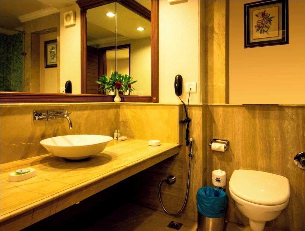 A bathroom with a large sink, mirror, and toilet.