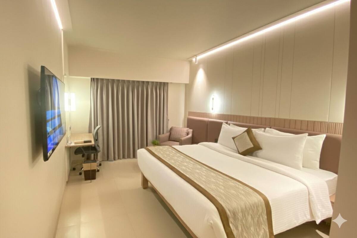 A modern hotel room with a large bed, a flat-screen TV, a bedside table, and a curtain.