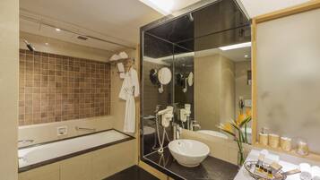 A modern bathroom with a large bathtub, a sink with a vanity, and a large mirror.