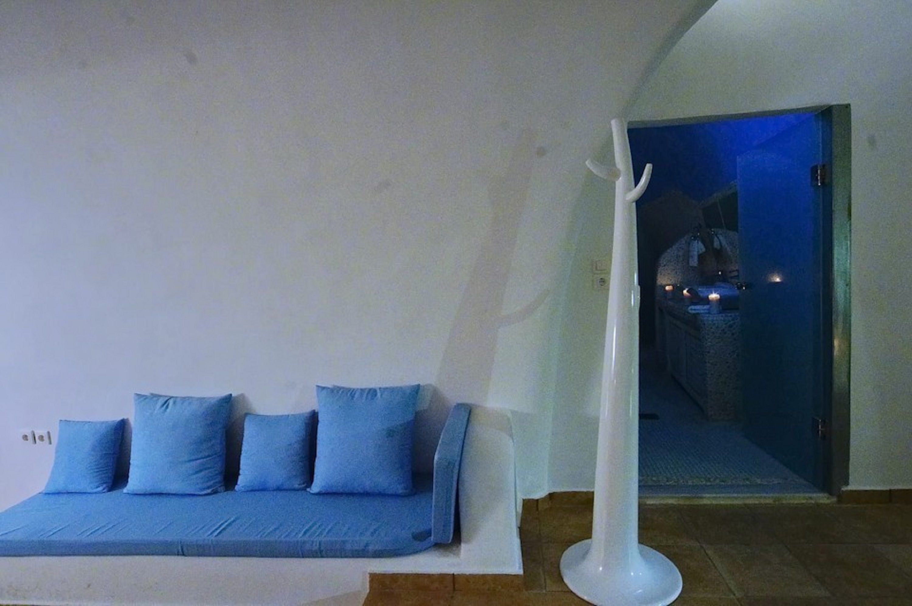 A room with a blue sofa and a white floor lamp.