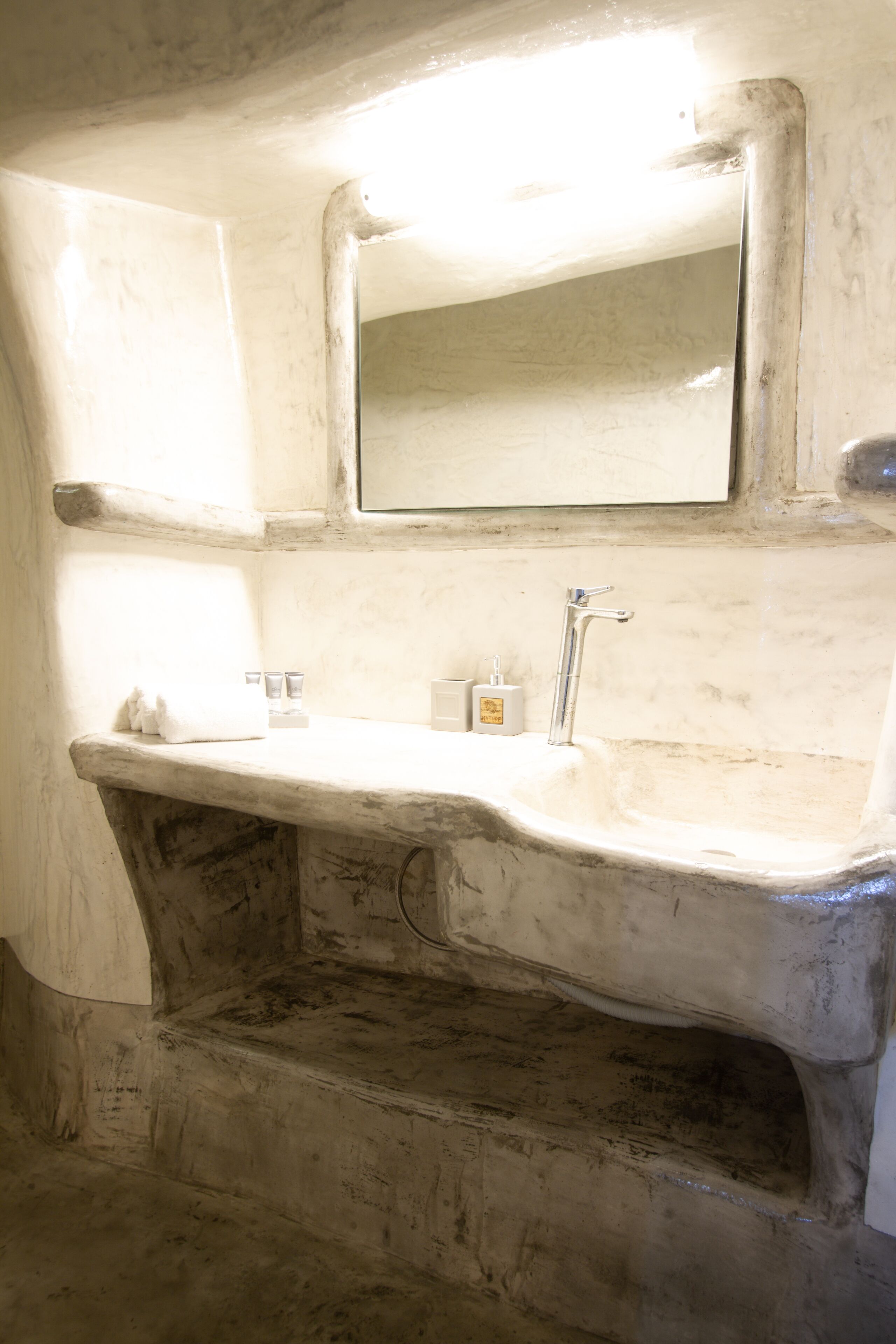 A bathroom with a marble sink, a mirror, and a towel.