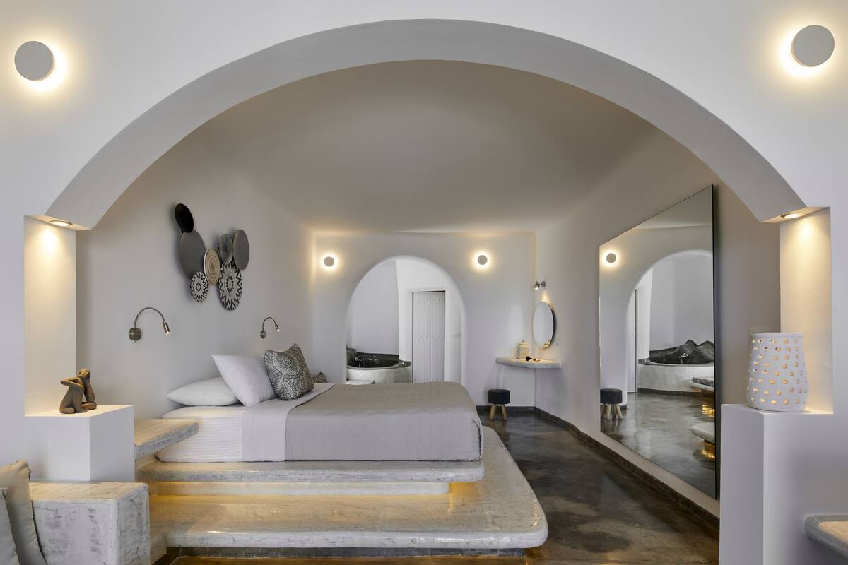 Une chambre à coucher moderne avec un grand lit, une coiffeuse et un miroir.