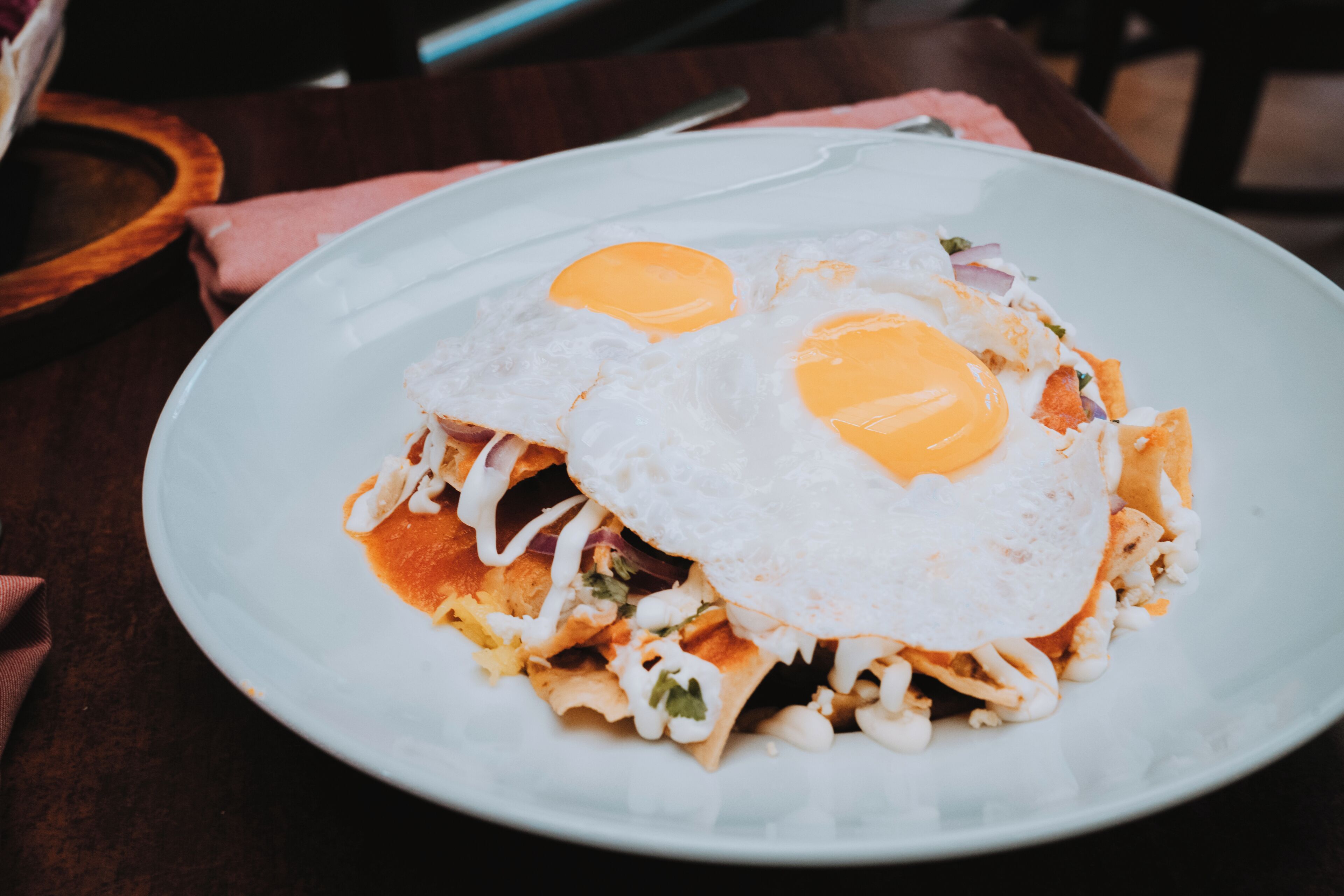 A plate of food with two fried eggs on top, served on a white plate.