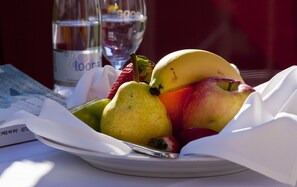 Fresh fruit and a refreshing glass of water are served in a dining area.