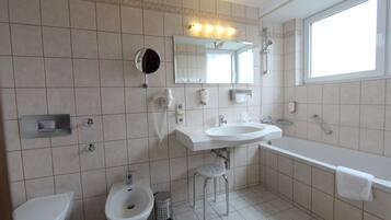 Ein Badezimmer mit Toilette, Bidet, Waschbecken und Badewanne.