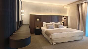 A modern hotel room with a large bed, a built-in desk, and a large mirror.