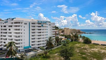 Ein mehrstöckiges Hotel mit Balkonen, Blick auf den Strand und blauem Himmel.