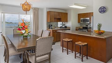 Una cocina moderna con armarios de madera, una isla central y una zona de comedor con mesa y sillas.